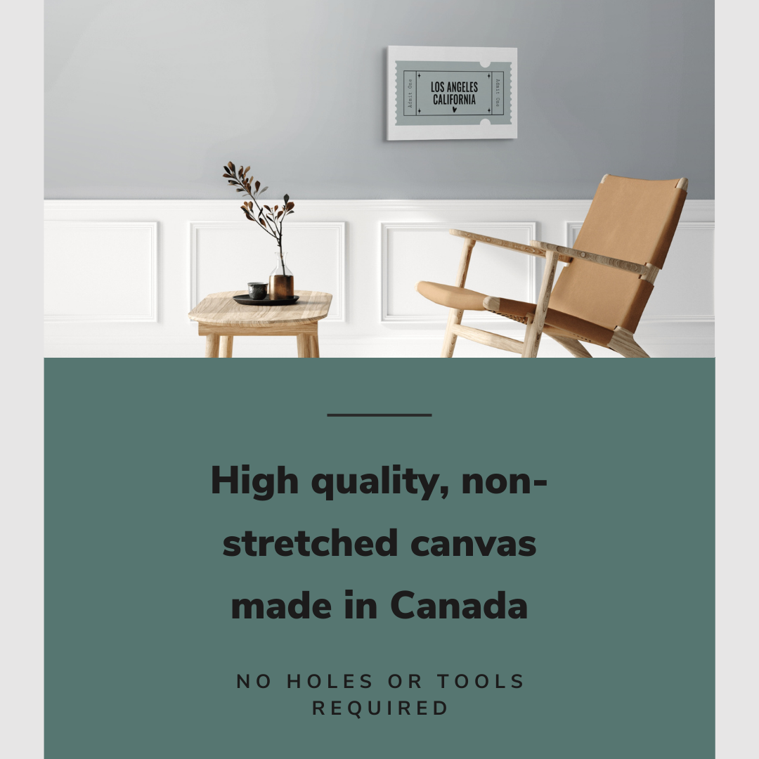 Lifestyle image of the horizontal 16x24” inch easy to hang canvas wall art hung in a living room above a chair and table with graphic saying "High quality, non-stretched canvas made in Canada."