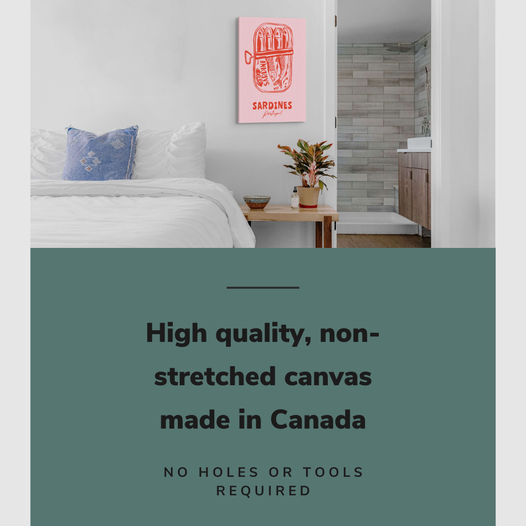 Lifestyle image of the vertical 20x30" inch easy to hang canvas wall art hung above a bed in a coastal themed bedroom overlooking a bathroom with graphic saying "High quality, non-stretched canvas made in Canada"