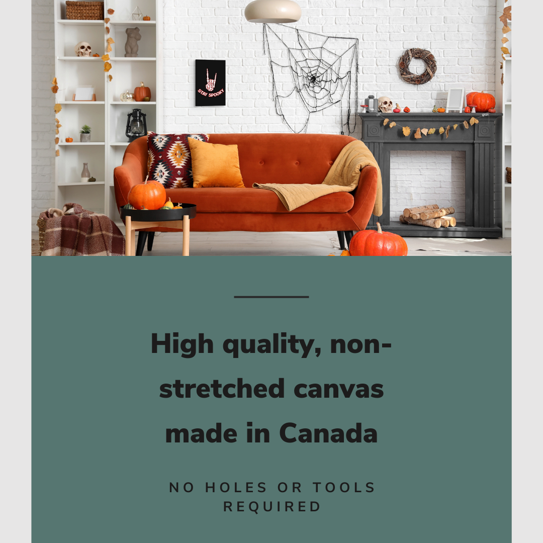 Lifestyle image of the vertical 12x18” inch easy to hang canvas wall art hung in a Halloween decorated living room above a couch and beside a fireplace with graphic saying "High quality, non-stretched canvas made in Canada."