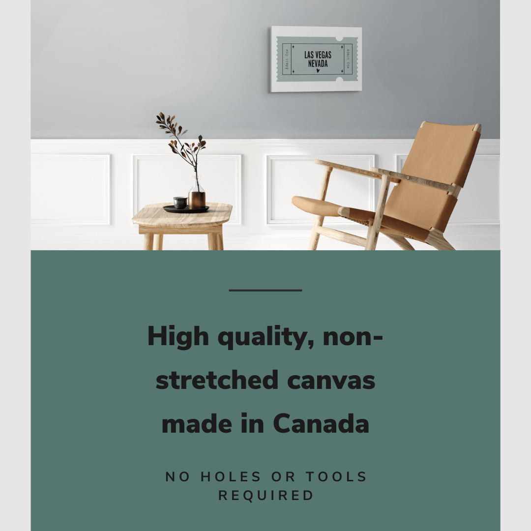Lifestyle image of the horizontal 16x24” inch easy to hang canvas wall art hung in living room above a chair and table with graphic saying "High quality, non-stretched canvas made in Canada."