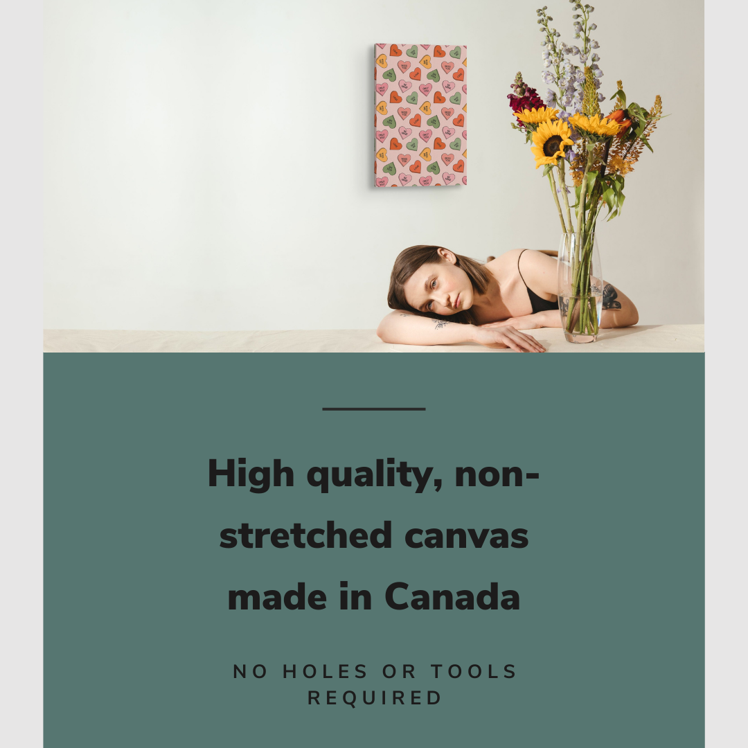 Lifestyle image of the vertical, 16x24 inch easy to hang canvas wall art hung in in a minimalist kitchen above a counter where a girl with a vase of flowers is sitting with graphic saying "High quality, non-stretched canvas made in Canada"