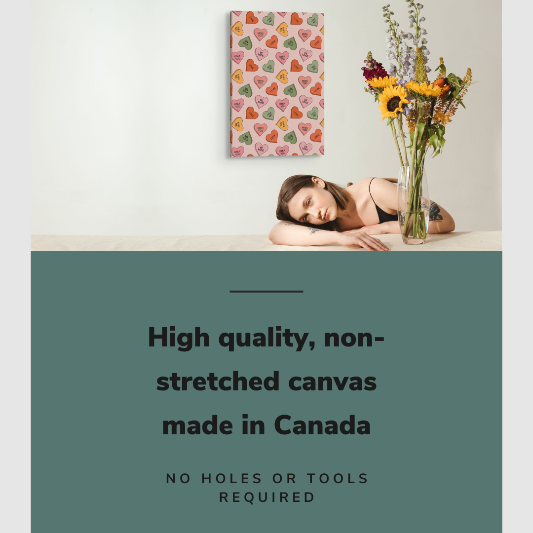 Lifestyle image of the vertical, 20x30 inch easy to hang canvas wall art hung in in a minimalist kitchen above a counter where a girl with a vase of flowers is sitting with graphic saying "High quality, non-stretched canvas made in Canada"