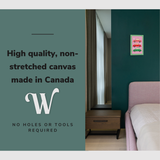 Lifestyle image of the vertical 12x18" inch easy to hang canvas wall art hung in above a bed in a bedroom with graphic saying "High quality, non-stretched canvas made in Canada"