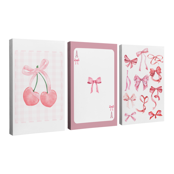 Set of 3, 2:3 vertical easy to hang canvas prints on a transparent background featuring images of a watercolor painting of two cherries tied together by a pink ribbon, an Ace card that has a ribbon for the Ace on a pink background, and a collection of hand painted ribbons in different styles of bows