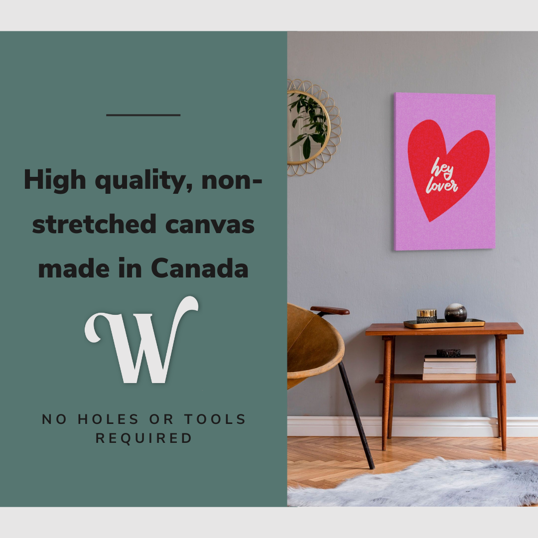 Lifestyle image of the vertical, 20x30 inch easy to hang canvas wall art hung in in a living room above an accent chair and side table beside a mirror with graphic saying "High quality, non-stretched canvas made in Canada"