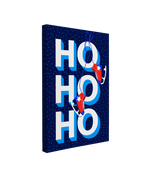 single, 2:3 vertical easy to hang canvas print on a transparent background featuring an image of "Ho Ho Ho" written in bold white font against a dark blue sky with snow in the background and red skates hanging off the font