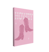 Single, 2:3 vertical easy to hang canvas print on a transparent background featuring an image of dark pink cowboy boots with "Howdy" written in a white western font behind the boots with white sparkles on a light pink background. 