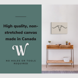 Lifestyle image of the horizontal 16x24” inch easy to hang canvas wall art hung in a hallway above a catch all table with graphic saying "High quality, non-stretched canvas made in Canada."