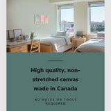 Lifestyle image of the vertical, 18x36 inch easy to hang canvas wall art hung in a dorm bedroom above a single bed beside a desk with graphic saying "High quality, non-stretched canvas made in Canada"