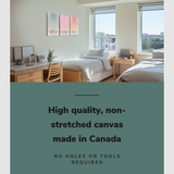 Lifestyle image of the vertical, 30x60 inch easy to hang canvas wall art hung in a dorm bedroom above a single bed beside a desk with graphic saying "High quality, non-stretched canvas made in Canada"