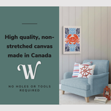 Lifestyle image of the vertical, 20x30” inch easy to hang canvas wall art hung in a coastal themed living room above a couch with graphic saying "High quality, non-stretched canvas made in Canada.