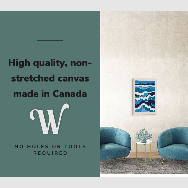 Lifestyle image of the vertical, 20x30” inch easy to hang canvas wall art hung in a coastal blue living room in-between two chairs with graphic saying "High quality, non-stretched canvas made in Canada"