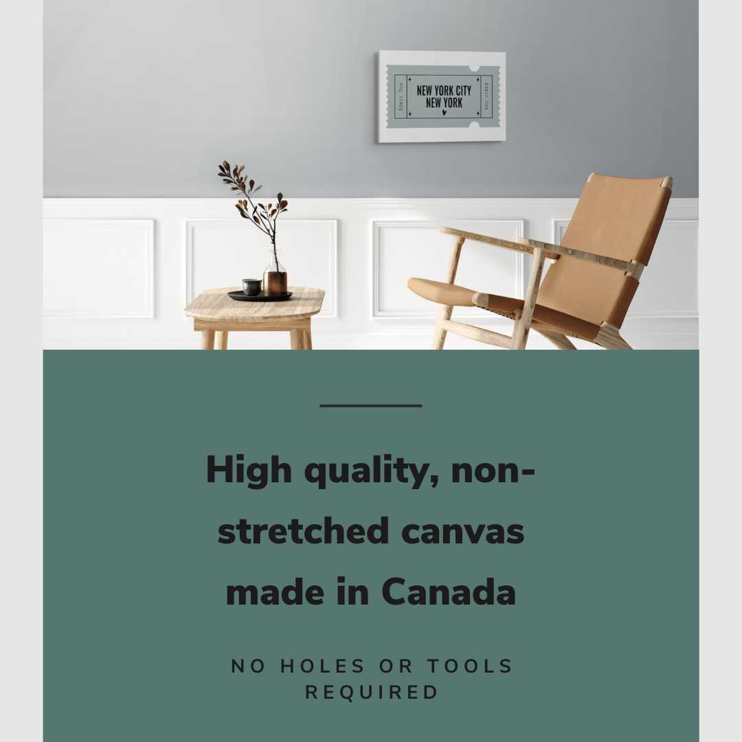 Lifestyle image of the horizontal 16x24” inch easy to hang canvas wall art hung in a living room above a chair and table with graphic saying "High quality, non-stretched canvas made in Canada."