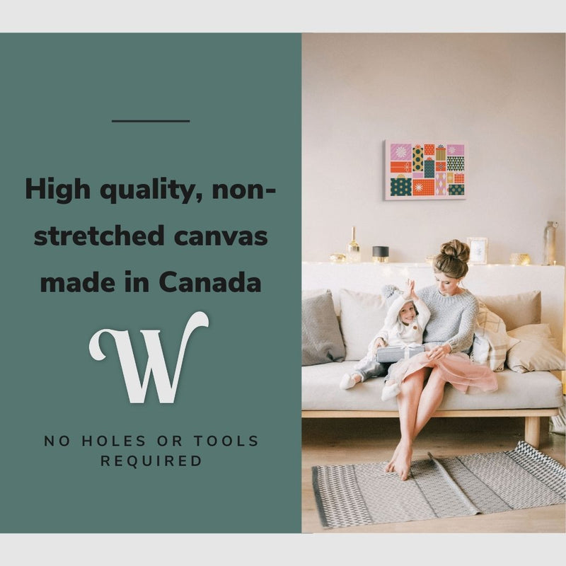 Lifestyle image of the vertical, 12x18 inch easy to hang canvas wall art hung in a living room above a couch with a mother and little girl opening gifts on christmas morning with graphic saying "High quality, non-stretched canvas made in Canada"