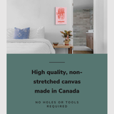 Lifestyle image of the vertical 16x24" inch easy to hang canvas wall art hung above a bed in a coastal themed bedroom overlooking a bathroom with graphic saying "High quality, non-stretched canvas made in Canada"