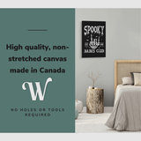 Lifestyle image of the vertical, 20x30” inch easy to hang canvas wall art hung in a bedroom over the side table beside the bed with graphic saying "High quality, non-stretched canvas made in Canada"