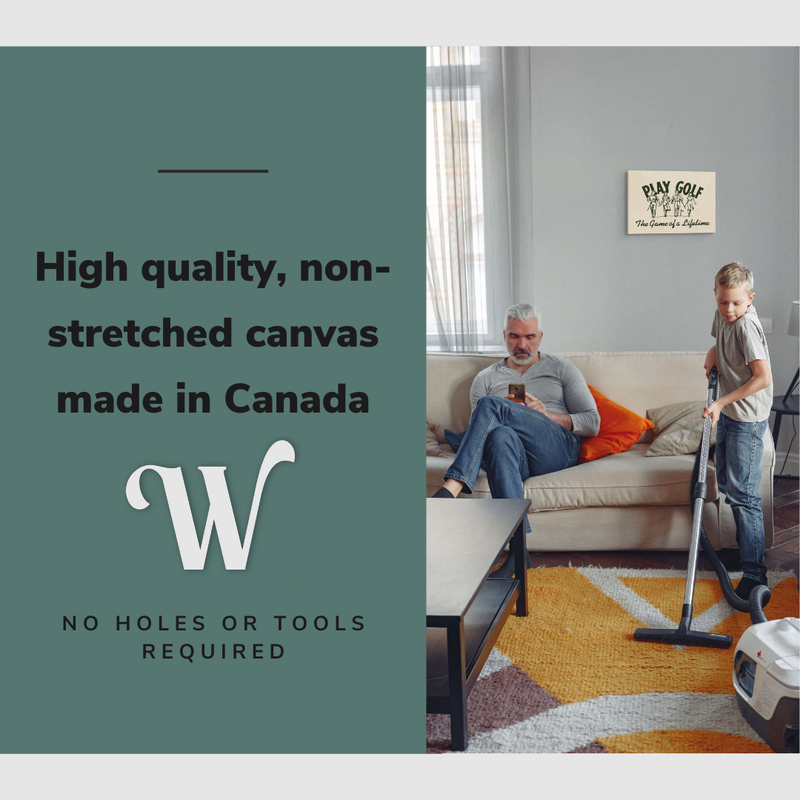 Lifestyle image of the horizontal 12x18” inch easy to hang canvas wall art hung in a living room above a couch with a man sitting on his phone and his son vacuuming the carpet around them with graphic saying "High quality, non-stretched canvas made in Canada."